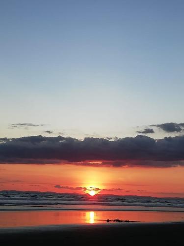 a sunset on the beach with the sun setting at Playa La Barqueta , Las Olas Tower Front in David