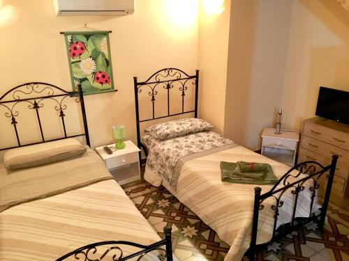 a bedroom with two beds and a tv in it at Salento Soleluna in Matino