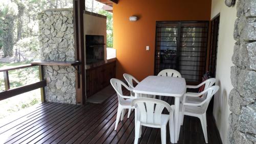 ein Esszimmer mit Tisch und Stühlen auf einer Terrasse in der Unterkunft La Ventarrón in Mar de las Pampas