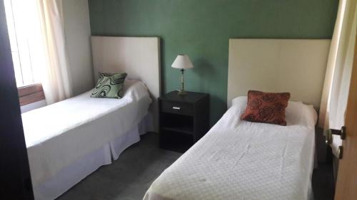 two beds in a room with green walls at La Ventarrón in Mar de las Pampas