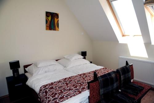 a bedroom with a bed with a red and white blanket at Arany Szőlő Wellness Apartmanház in Hévíz