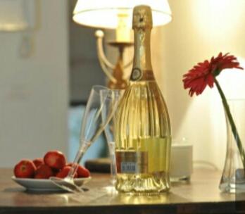 a bottle of wine on a table with a plate of fruit at ARCOBELLO Suite Rooms in Castellana Grotte