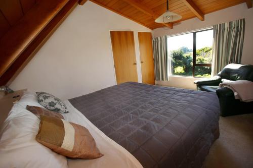 Un dormitorio con una cama grande y una ventana en Capeview Cottage en Opotiki