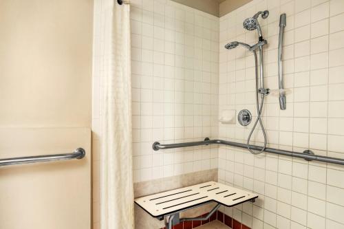 a bathroom with a shower with a bench in it at Belmont Inn & Suites in Florida City