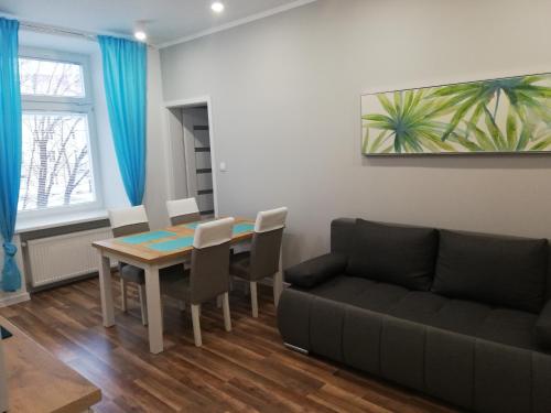 sala de estar con mesa y sofá en Apartament Poniatowskiego, en Radom