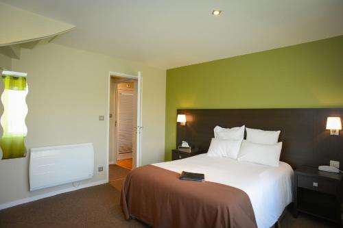 a hotel room with a bed and a tv at Logis Hôtel Restaurant l'Auberge Normande in Carentan
