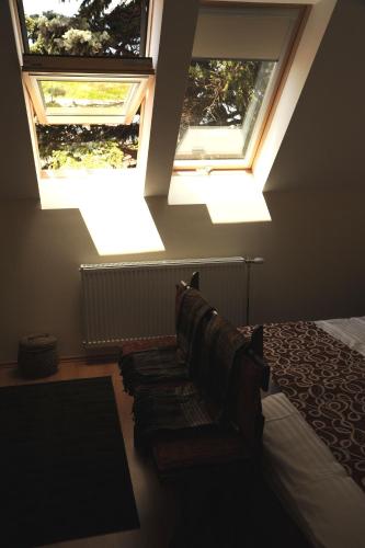 a bedroom with two skylights and a bed and a couch at Arany Szőlő Wellness Apartmanház in Hévíz