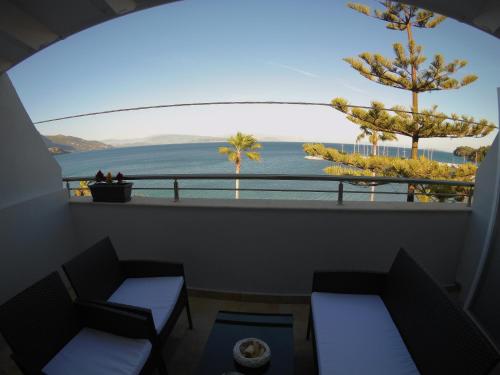 a balcony with two chairs and a view of the ocean at Onar Corfu Aparts & Studios in Ýpsos
