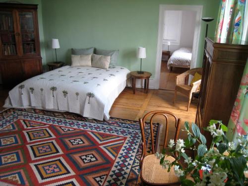 1 dormitorio con cama y alfombra en Chambres d'hôtes Le Clos Saint Léonard, en Boersch