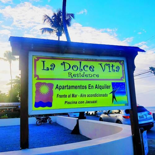 a sign in front of a beach with a palm tree at A La Dolce Vita Beachfront Hotels, Las Terrenas, Samana in Las Terrenas