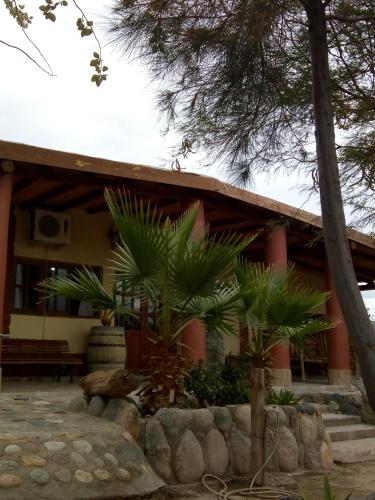 a building with palm trees in front of it at Hotel de Campo Oeste Paraíso in La Ciénaga