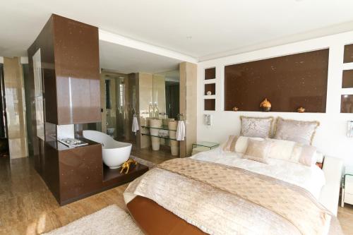 a bedroom with a large bed and a bathroom at GORDON's SHORE LUXURY APARTMENTS - Solar Powered in Gordonʼs Bay