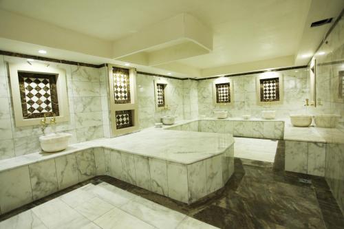 een grote badkamer met 2 wastafels en 2 spiegels bij Grand Akçalı Otel in İskenderun