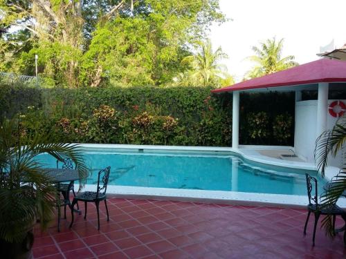 uma piscina com mesas e cadeiras ao lado de uma casa em Balcon Gueela em Santa Cruz, Huatulco