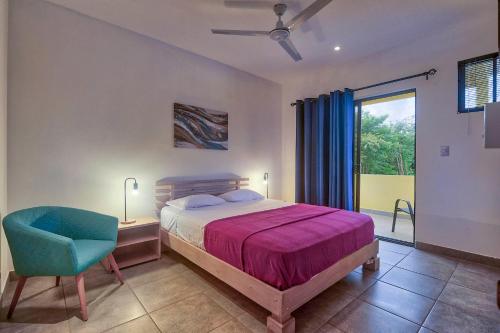 a bedroom with a bed and a desk and a chair at Tamarindo Garden Boutique Homes in Tamarindo