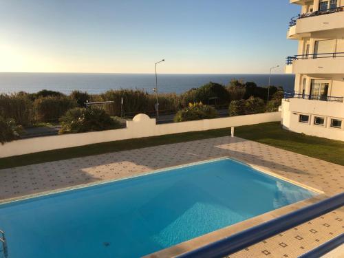 a swimming pool with a view of the ocean at Ericeira Ocean View Apartment in Ericeira