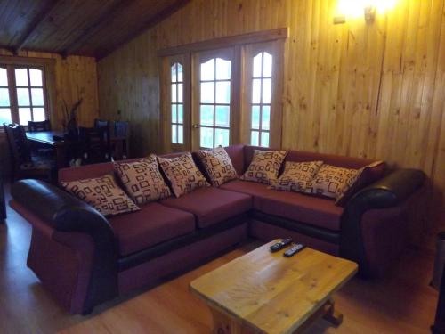 a living room with a couch and a coffee table at Hostal Robinson in Puerto Puyuhuapi