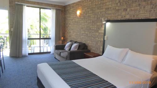 a hotel room with a bed and a couch at Tower Court Motel - adults only haven in Hervey Bay