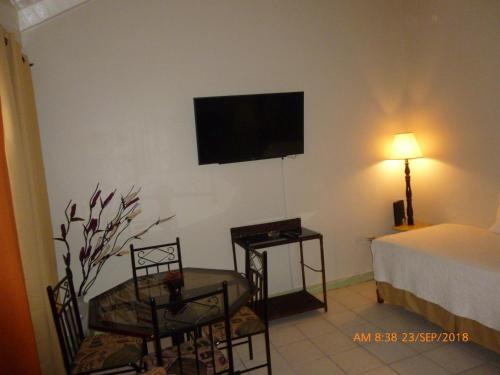 a room with a bed and a television on a wall at SandCastles # E26 in Ocho Rios