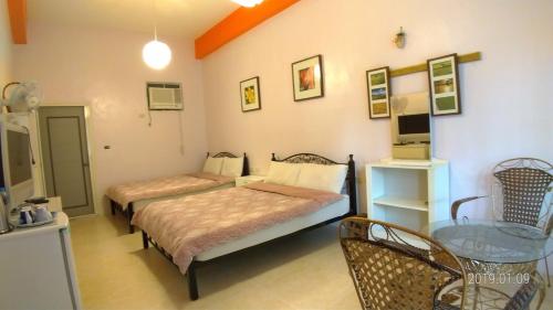 a bedroom with two beds and a glass table at 悦來民宿 台東縣民宿334號 in Taiping