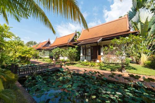 a house with a pond in front of it at Khaolak Bhandari Resort & Spa - SHA Extra Plus in Khao Lak