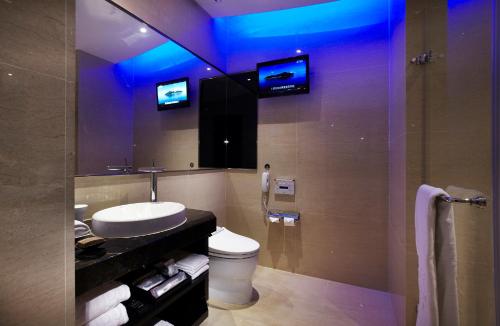 a bathroom with a sink and a toilet and a mirror at The Tango Hotel Taipei ChangAn in Taipei