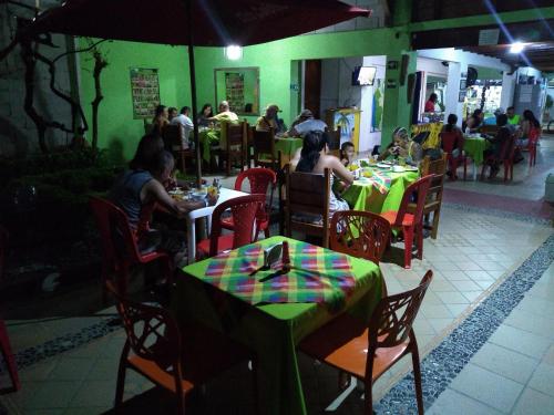 un grupo de personas sentadas en mesas en un restaurante en Hostal Capurgana, en Capurganá