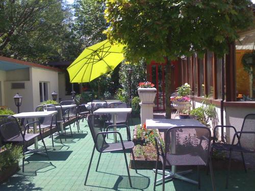a row of tables and chairs with a yellow umbrella at Metropol in Biel
