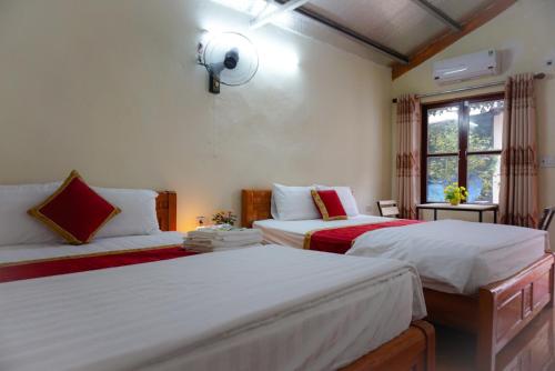 um quarto com 2 camas e uma janela em Tam Coc Riverside Homestay em Ninh Binh