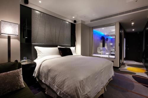 a bedroom with a large white bed and a window at The Tango Hotel Taipei ChangAn in Taipei