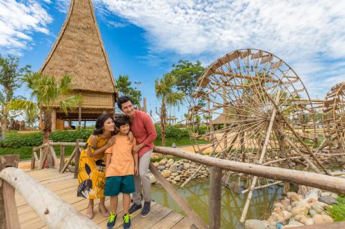 a family standing on a bridge at a theme park at Vinpearl Resort & Golf Nam Hoi An in Hoi An