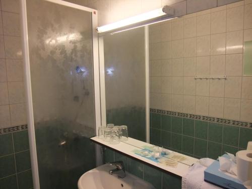 a bathroom with a shower and a sink and a mirror at Hotel Esplanad in Mariehamn