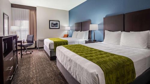 a hotel room with two beds and a desk at Best Western Rock Hill in Rock Hill