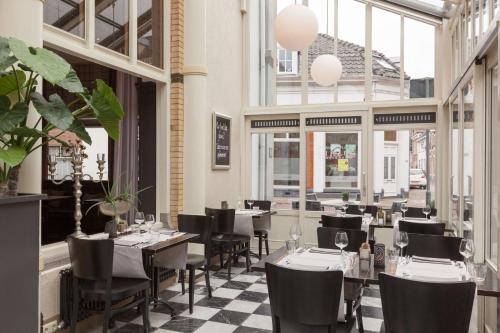 - un restaurant avec des tables et des chaises dans une salle dotée de fenêtres dans l'établissement Best Western Hotel Baars, à Harderwijk