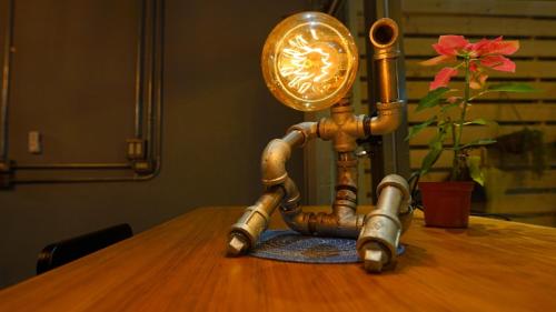 a lamp sitting on top of a wooden table at MILU Backpacker Hostel in Puli