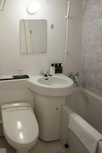 a bathroom with a toilet and a sink and a tub at Center Hotel Narita2 R51 in Narita