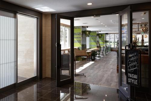 a restaurant with sliding glass doors and a dining area at Center Hotel Narita2 R51 in Narita