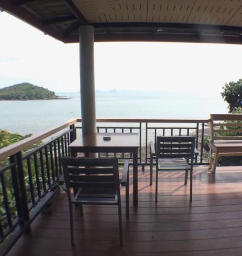 a balcony with chairs and a table and the ocean at HEAVEN HILL LANTA in Ko Lanta