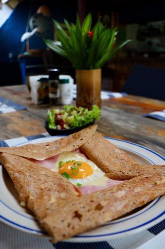 a plate of food with an egg and chips on a table at Le BDM PLAYITA in Las Galeras