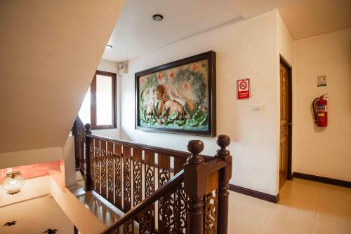 a hallway with a staircase with a painting on the wall at Ban Ao Thong in Trang