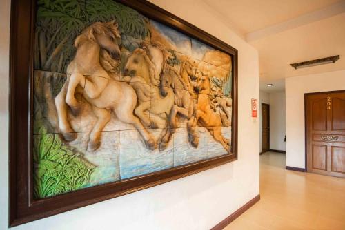 a large painting of horses on a wall in a hallway at Ban Ao Thong in Trang