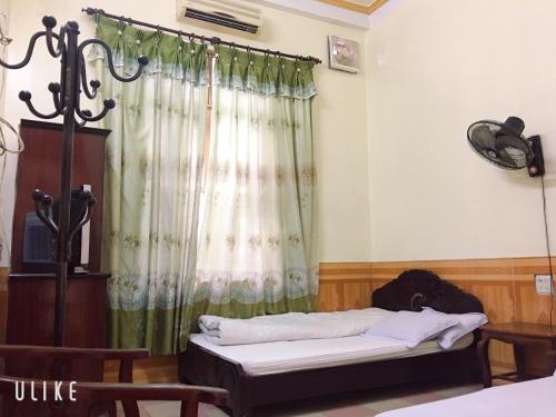 een kamer met een bed en een gordijn bij Vân Anh Guesthouse in Yên Bái