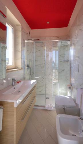 a bathroom with a shower and a sink and a toilet at Hotel Sydney in San Benedetto del Tronto