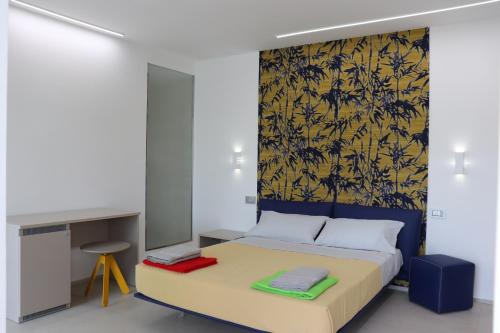 1 dormitorio con 1 cama con papel pintado de color amarillo y azul en Villa Emma, en Montegranaro