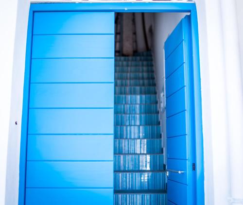 a blue garage door with a staircase in the background at Zagma Un Passo Dal Mare in Canneto