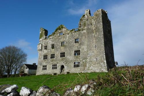 un viejo castillo sentado en la cima de una colina en Coastal View House, en Doolin