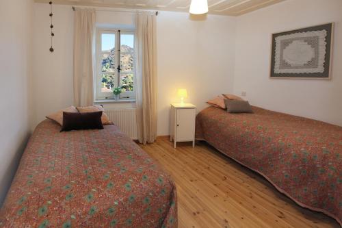 2 camas en una habitación con ventana en Kalopanayiotis Cottage, en Kalopanayiotis
