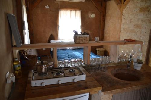 a kitchen with a stove and a sink in a room at Desert Days mud cabin's Resort in Zuqim