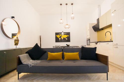 un soggiorno con divano blu e cuscini gialli di Real Delux Apartment next to Gozsdu & Synagogue a Budapest