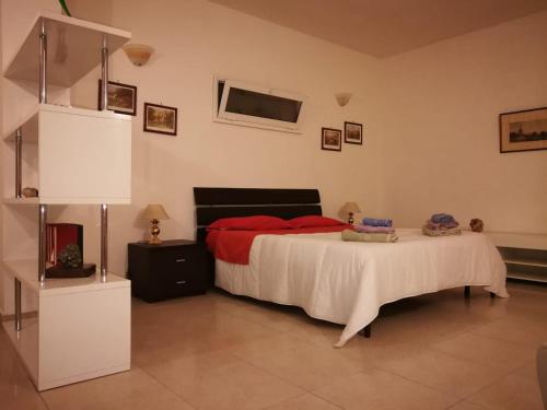 ein Schlafzimmer mit einem großen Bett mit roten Kissen in der Unterkunft Behara in Marina di Ragusa